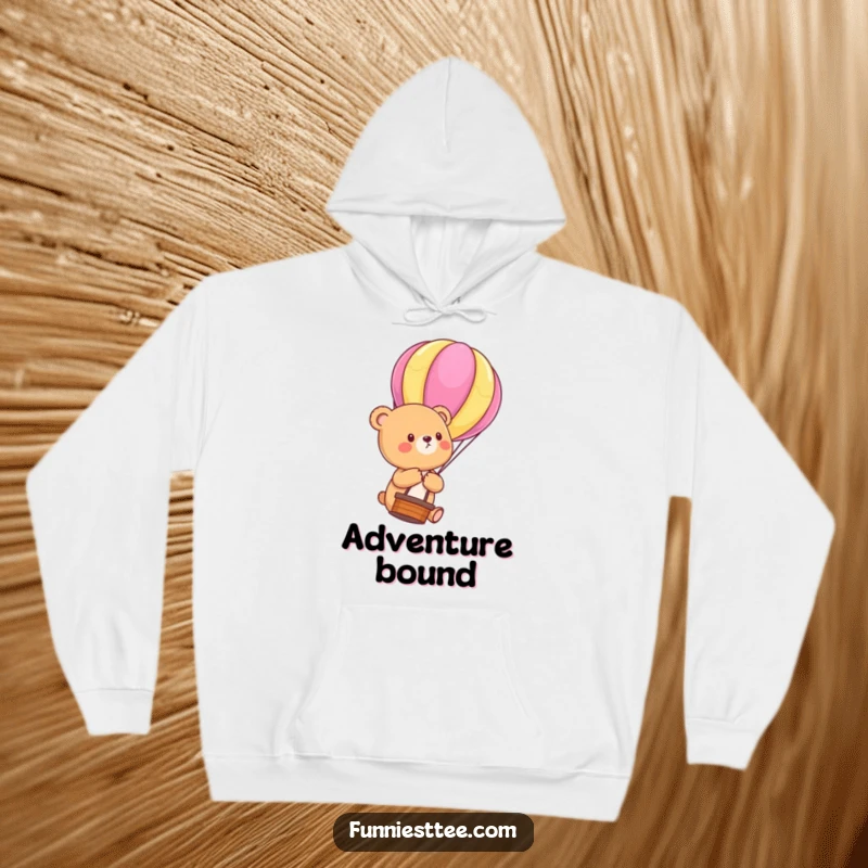 Funny Bear Cub Balloon Hoodie: Warm sweatshirt with a cute bear cub floating upwards, holding a colorful hot air balloon string, a funny cozy adventure piece.