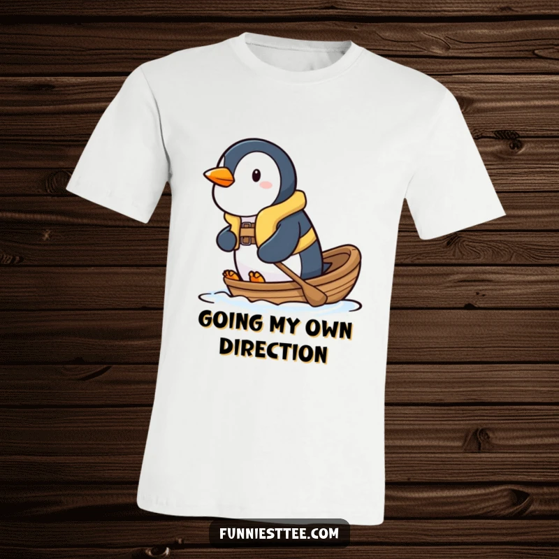 Funny penguin t-shirt showing a determined penguin in a small life vest, paddling a little boat with great effort.