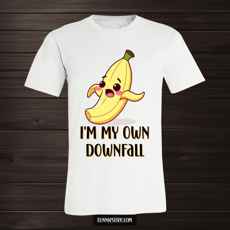 Funny t-shirt with a surprised cartoon banana peel grinning as it comically slips on its own peel, a classic slapstick prank.